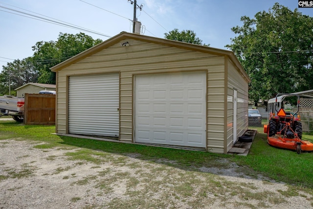 detached garage featuring fence