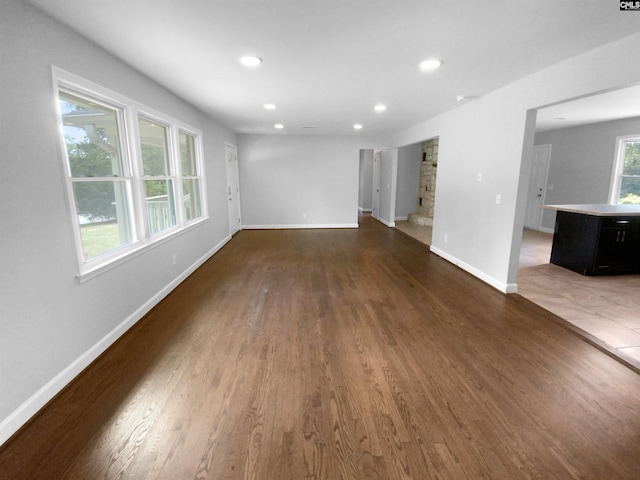 unfurnished living room with recessed lighting, dark wood finished floors, and baseboards