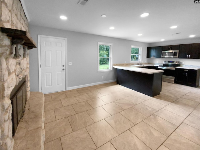 kitchen with recessed lighting, light countertops, appliances with stainless steel finishes, dark cabinets, and baseboards