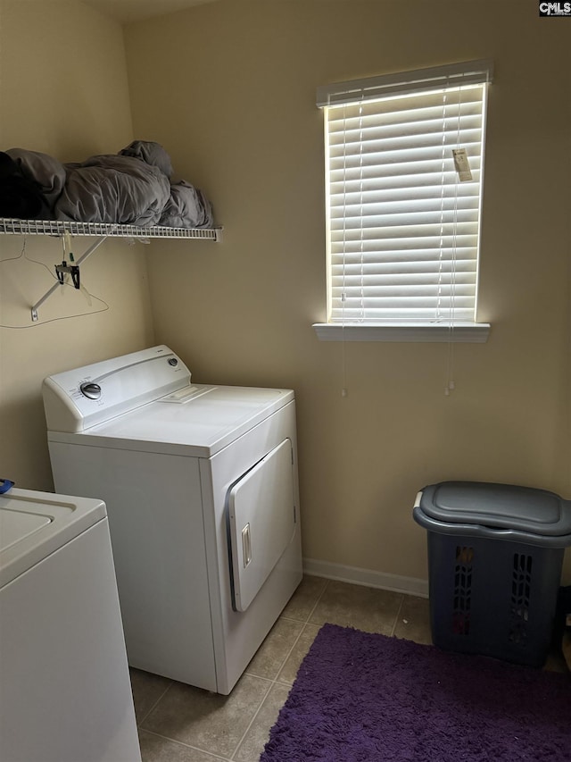 laundry area with light tile patterned floors, baseboards, laundry area, and independent washer and dryer