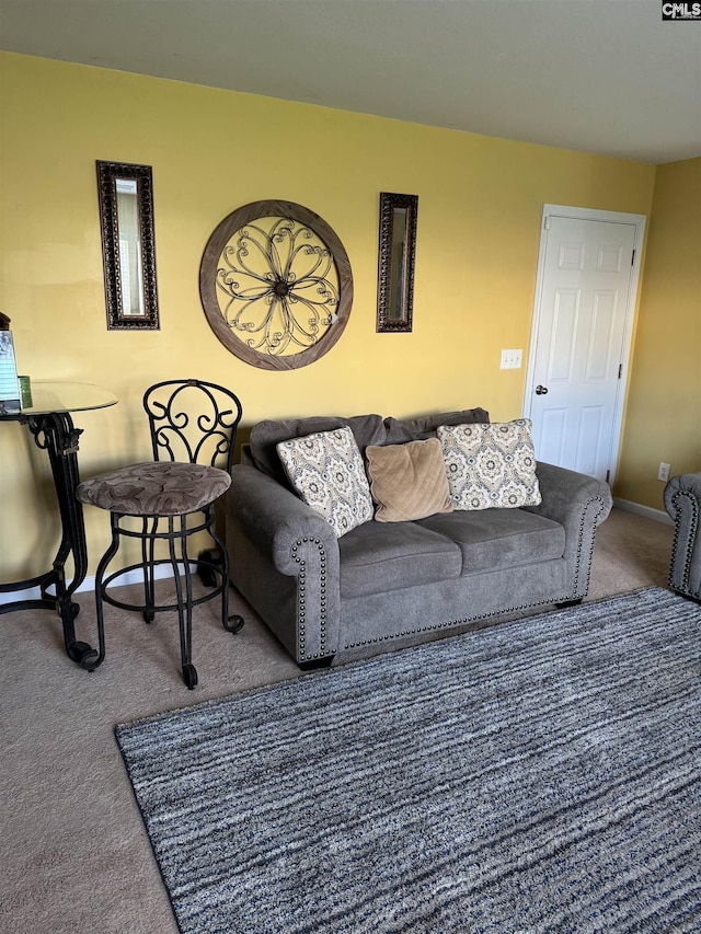 carpeted living area featuring baseboards