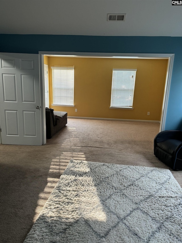 living area featuring carpet floors and visible vents