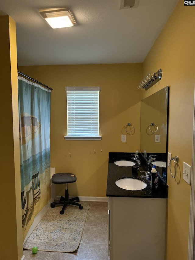 bathroom featuring double vanity, a shower with curtain, a sink, and tile patterned floors