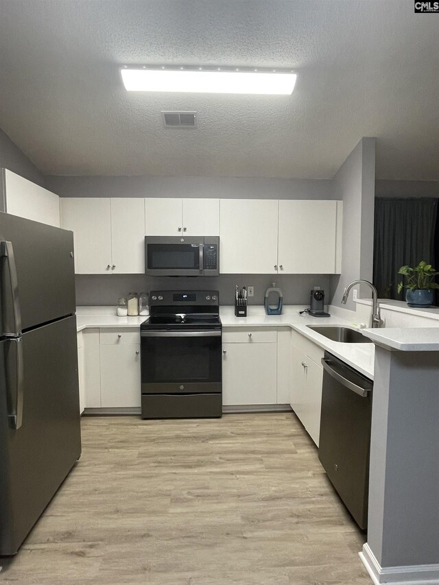 kitchen featuring light wood-type flooring, stainless steel dishwasher, lofted ceiling, and range with electric cooktop