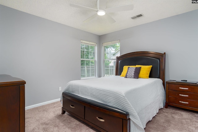 carpeted bedroom featuring a textured ceiling and ceiling fan