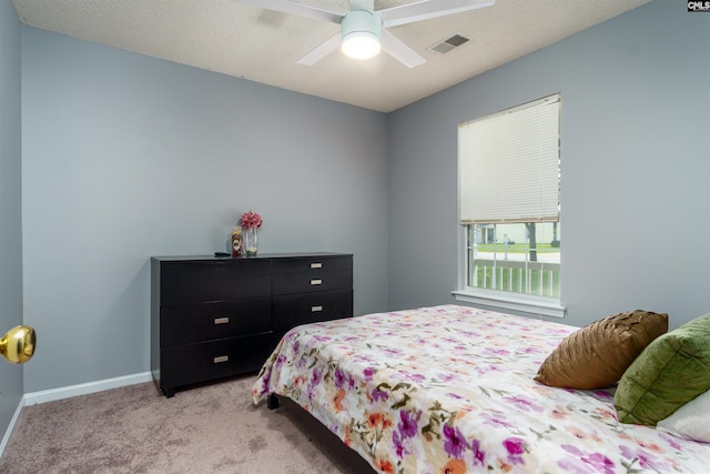 carpeted bedroom featuring a textured ceiling and ceiling fan