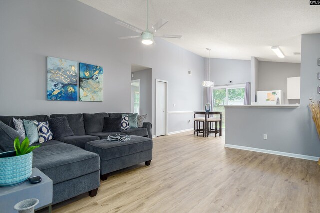 living room with light wood-type flooring, ceiling fan, and lofted ceiling