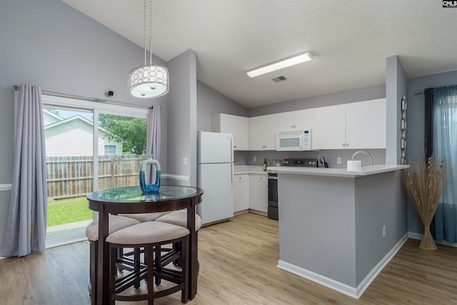 kitchen with white appliances, plenty of natural light, and light wood-type flooring