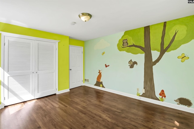 unfurnished bedroom featuring a closet, baseboards, and wood finished floors