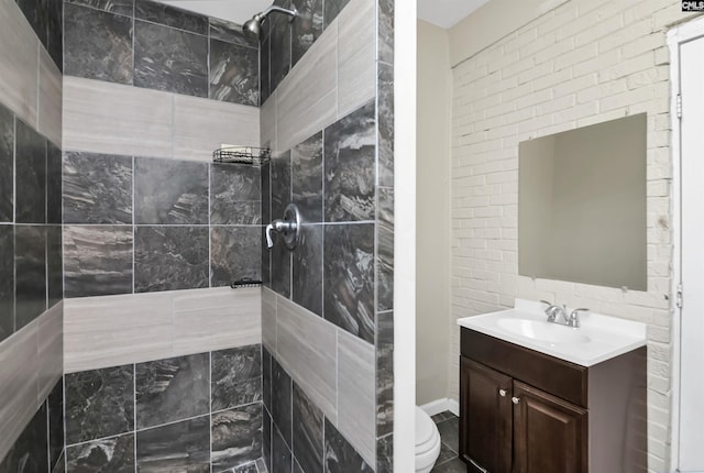 bathroom featuring a tile shower, toilet, and vanity