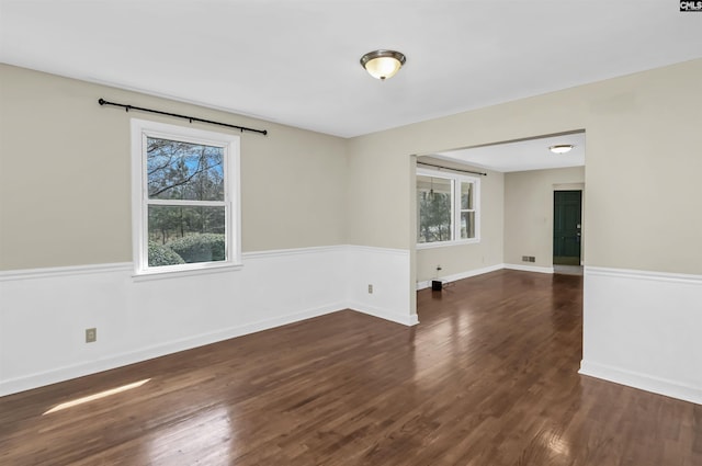 unfurnished room featuring baseboards and dark wood-style floors