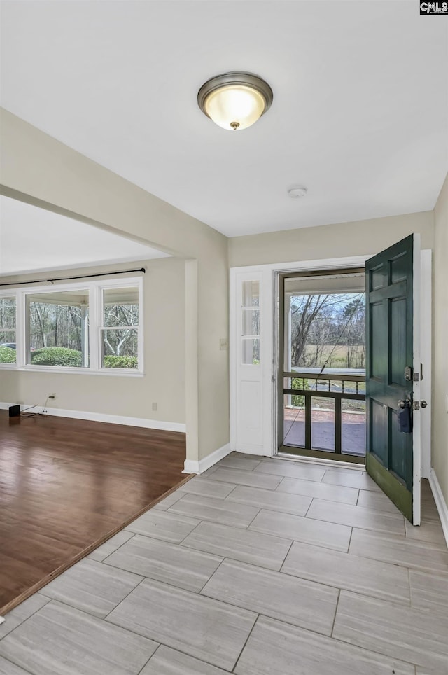 entrance foyer with baseboards and wood finish floors