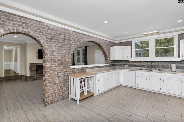 kitchen featuring visible vents, a sink, decorative backsplash, white cabinets, and dishwasher