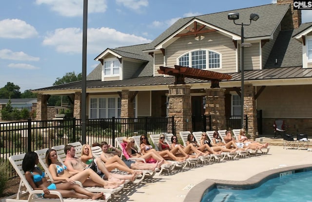 rear view of property featuring a patio area and a community pool