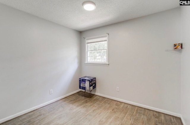 unfurnished room featuring a textured ceiling and wood-type flooring