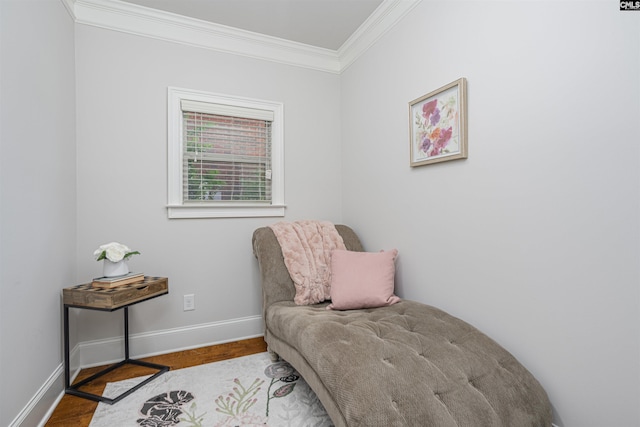 living area featuring ornamental molding, baseboards, and wood finished floors