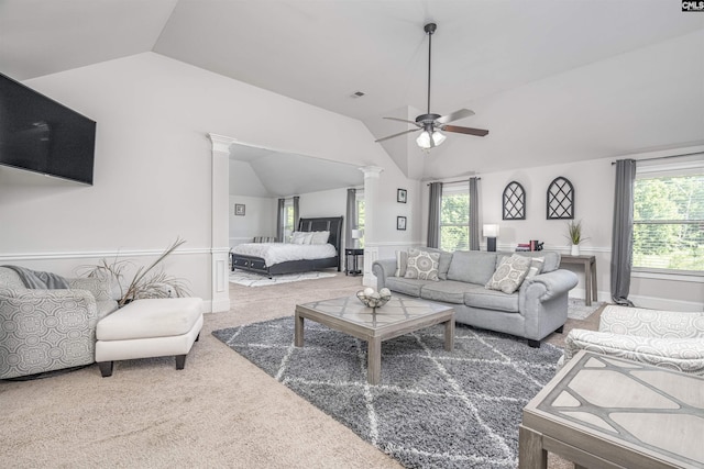 carpeted living room featuring a healthy amount of sunlight, decorative columns, visible vents, and vaulted ceiling