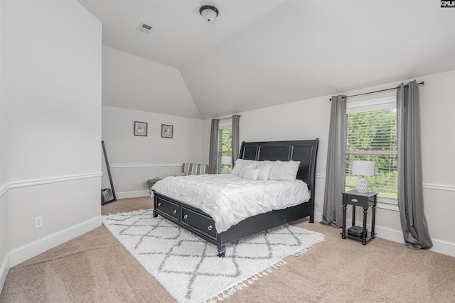 bedroom featuring lofted ceiling, baseboards, visible vents, and light colored carpet