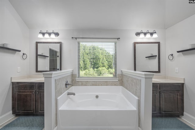 full bathroom with two vanities, a garden tub, and baseboards