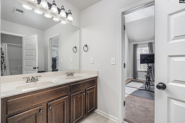 bathroom with visible vents, a sink, baseboards, and double vanity