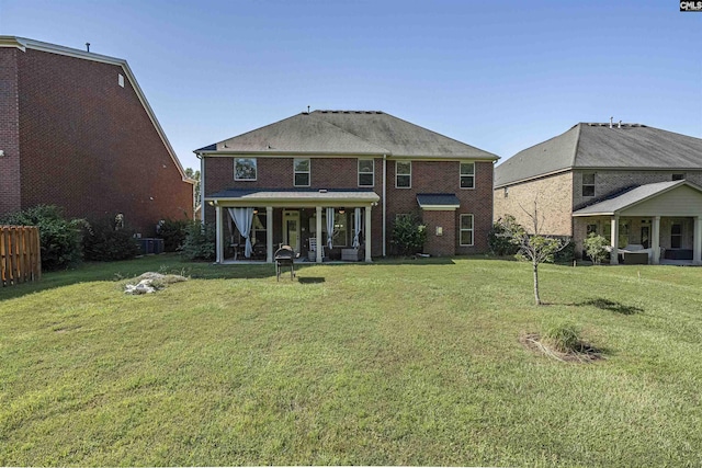 rear view of house featuring a yard, brick siding, and central AC unit