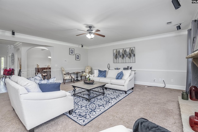 living room with arched walkways, carpet, visible vents, and crown molding