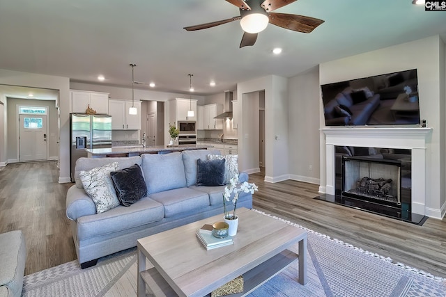 living room featuring light hardwood / wood-style floors and ceiling fan