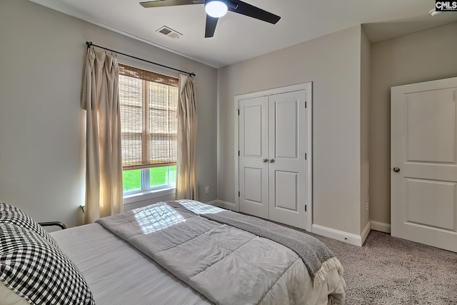 bedroom with a closet, ceiling fan, and light colored carpet