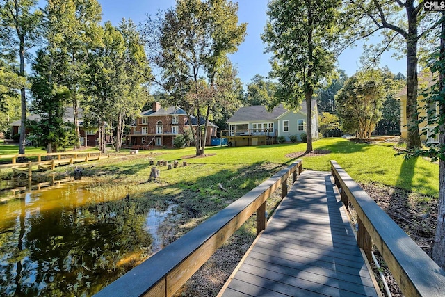 view of dock featuring a yard and a deck with water view