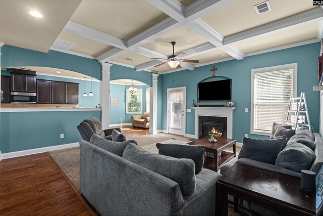 living room featuring coffered ceiling, ceiling fan with notable chandelier, ornamental molding, wood-type flooring, and beamed ceiling