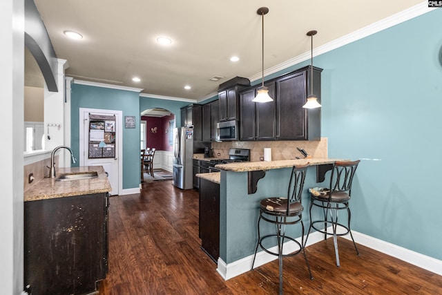 kitchen with sink, decorative light fixtures, appliances with stainless steel finishes, and dark wood-type flooring