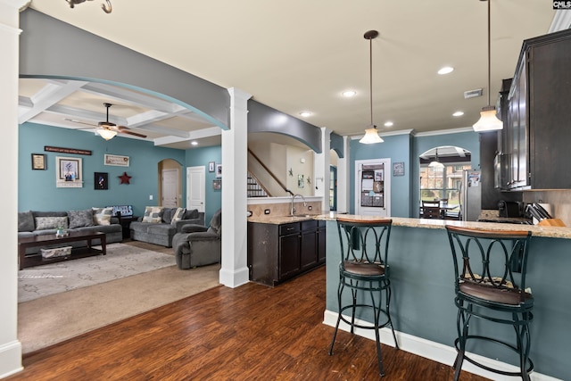 kitchen with dark hardwood / wood-style flooring, coffered ceiling, kitchen peninsula, and dark brown cabinetry