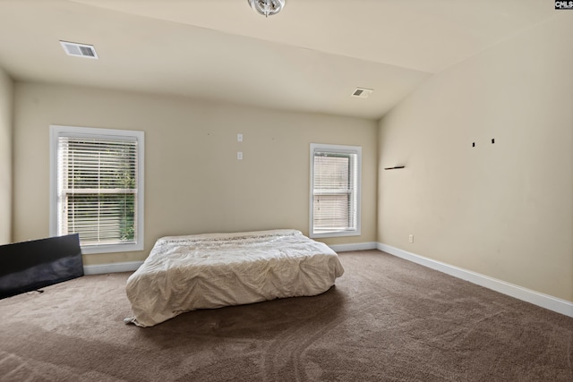 bedroom with carpet floors and lofted ceiling