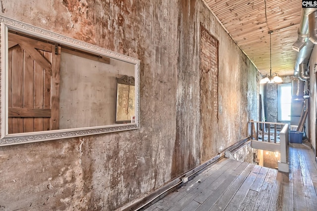 interior space with hardwood / wood-style floors, a barn door, a notable chandelier, and wooden ceiling