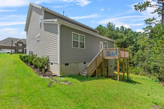 rear view of house featuring a wooden deck and a yard