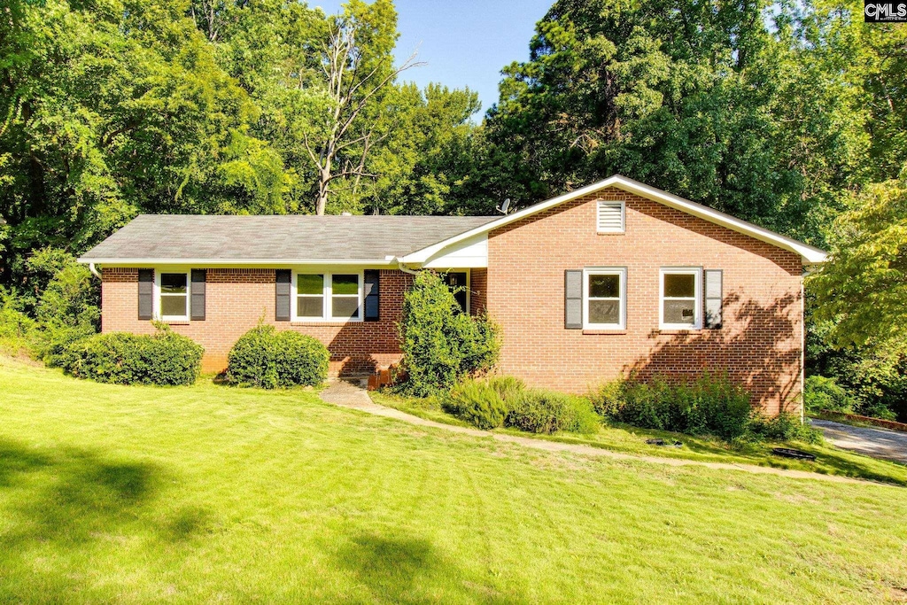 ranch-style house featuring brick siding and a front yard