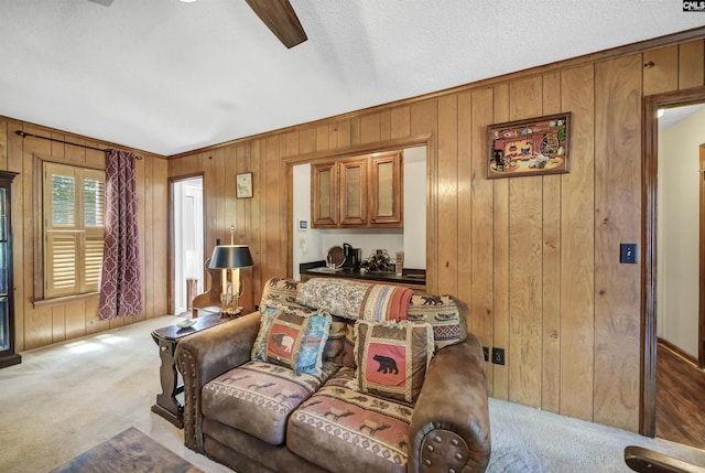 carpeted living area featuring wood walls