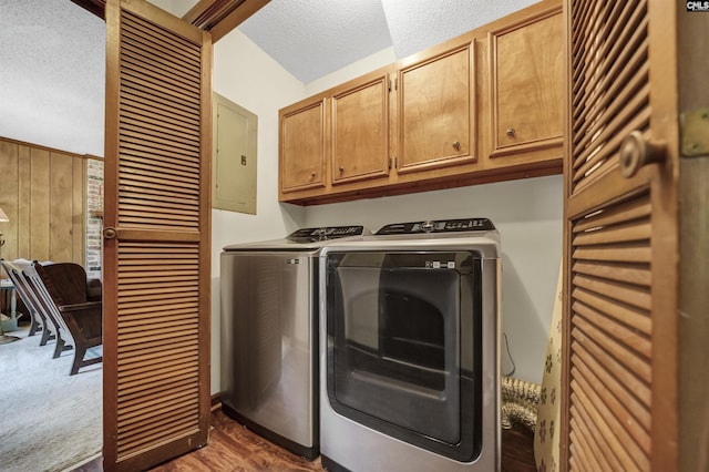 laundry area featuring a textured ceiling, washer and dryer, cabinet space, electric panel, and dark wood-style floors