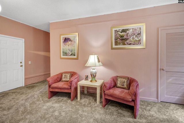 living area with carpet, baseboards, and crown molding