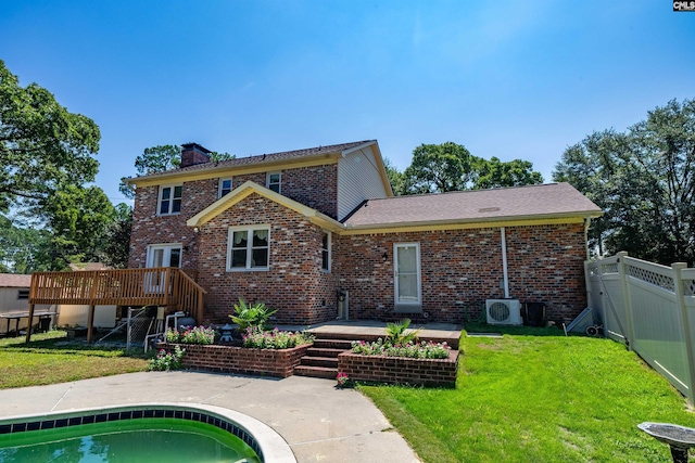 back of property featuring a deck, a fenced backyard, brick siding, a yard, and a chimney