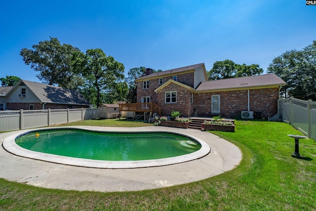 view of pool with a yard, a storage unit, a deck, a fenced backyard, and an outdoor structure