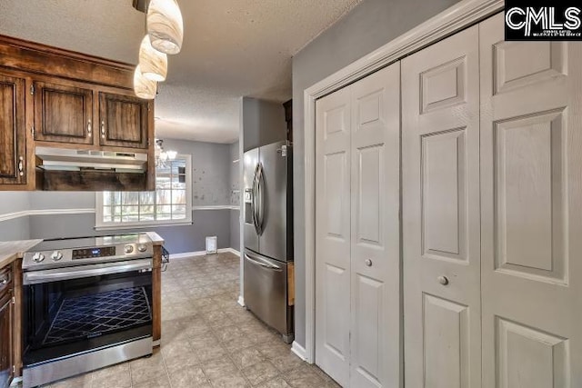 kitchen featuring a textured ceiling, appliances with stainless steel finishes, light tile patterned flooring, and dark brown cabinets