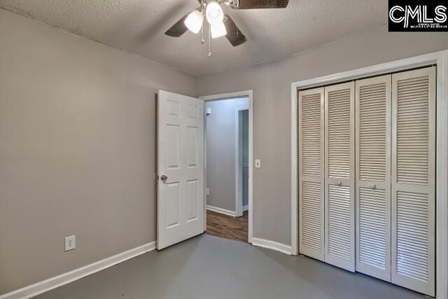 unfurnished bedroom featuring ceiling fan, a closet, a textured ceiling, and hardwood / wood-style floors