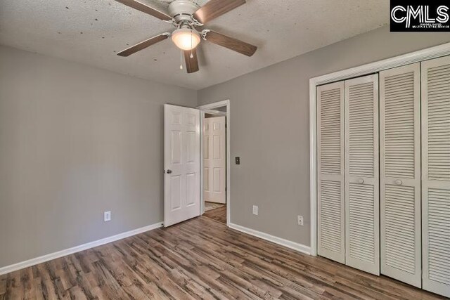 unfurnished bedroom with ceiling fan, hardwood / wood-style flooring, a closet, and a textured ceiling