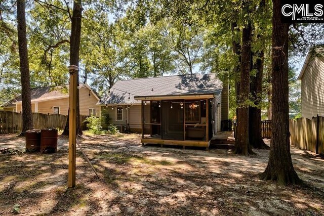 rear view of property featuring a wooden deck