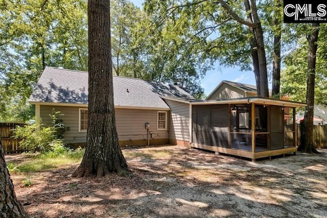 rear view of property featuring a sunroom