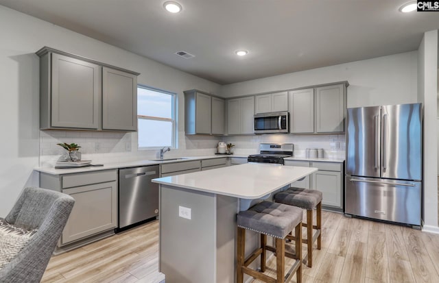 kitchen featuring sink, a center island, light wood-type flooring, and appliances with stainless steel finishes