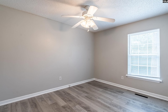 empty room featuring a textured ceiling, ceiling fan, and hardwood / wood-style floors