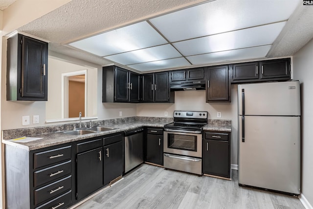 kitchen with sink, a textured ceiling, light hardwood / wood-style flooring, and appliances with stainless steel finishes