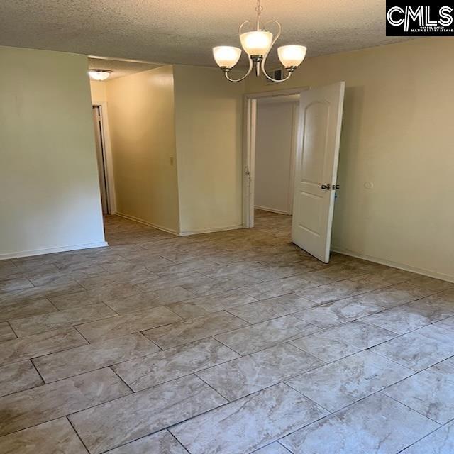 1208 Bush River Rd Unit F-7, Columbia, SC 29210 - empty room with a textured ceiling, a chandelier, and baseboards